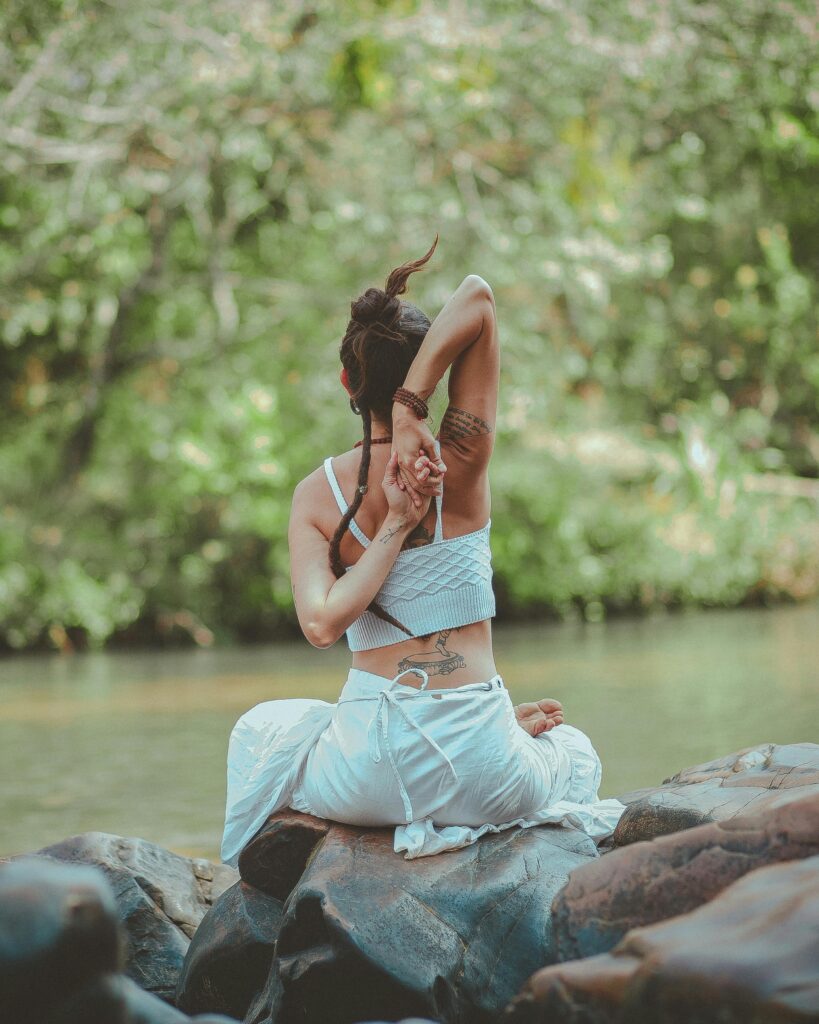 pexels-photo-2529371-2529371 A woman in a yoga pose by a calm river, surrounded by nature, embodying peace and tranquility.
